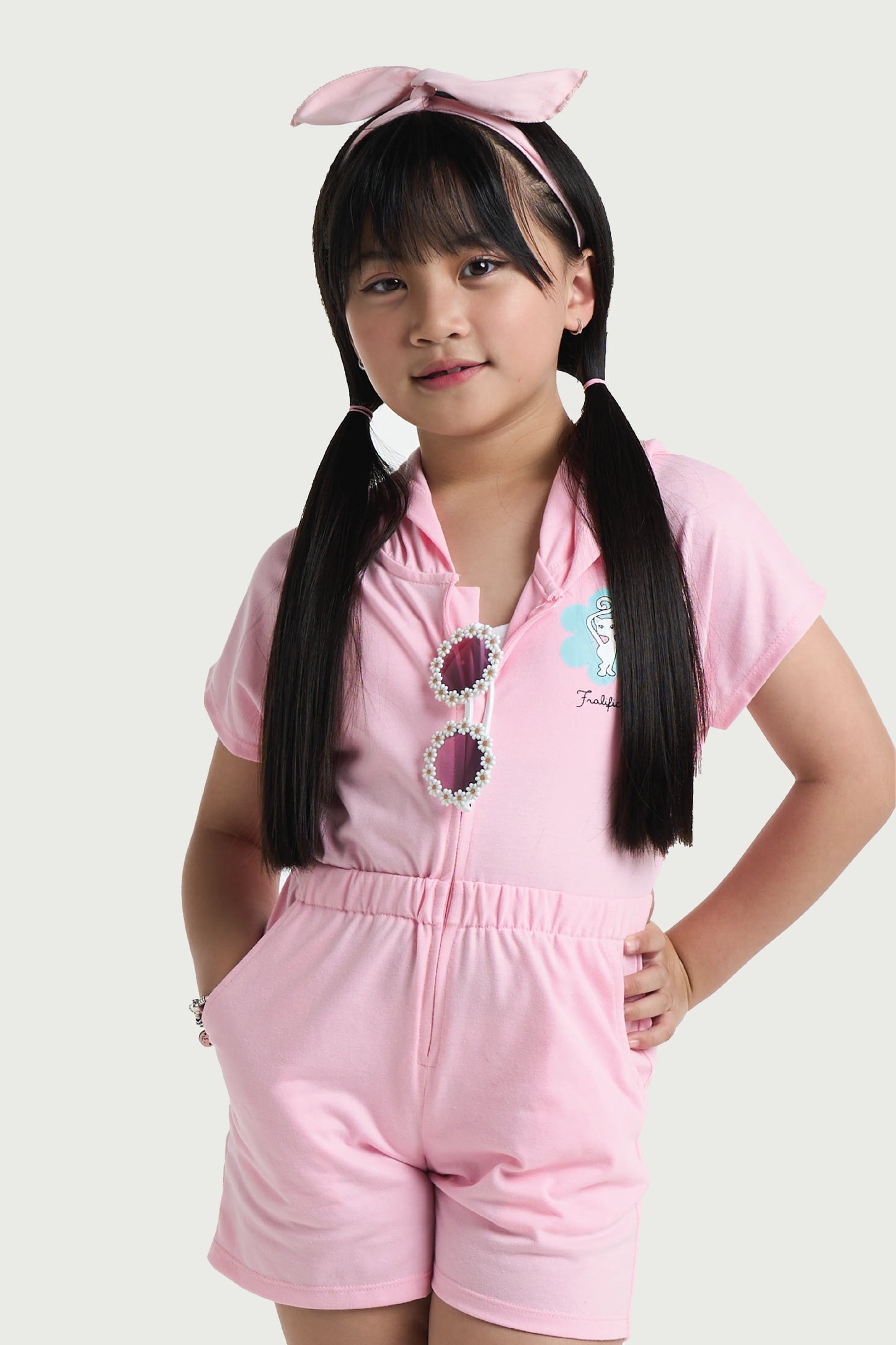 Close-up of light pink hood on girls romper with soft cotton fabric