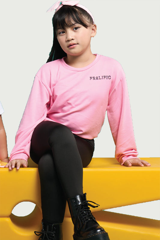 Girl in black cotton leggings and pink top sitting on yellow bench – comfy and stylish kidswear